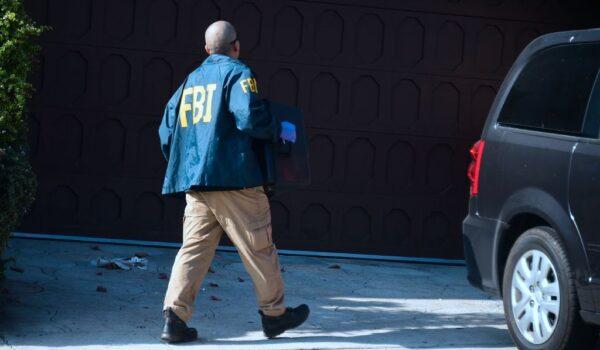 An FBI agent carries a case from the home of then Los Angeles Councilman José Huizar in Los Angeles on Nov. 7, 2018. (Frederic J. Brown/AFP via Getty Images)
