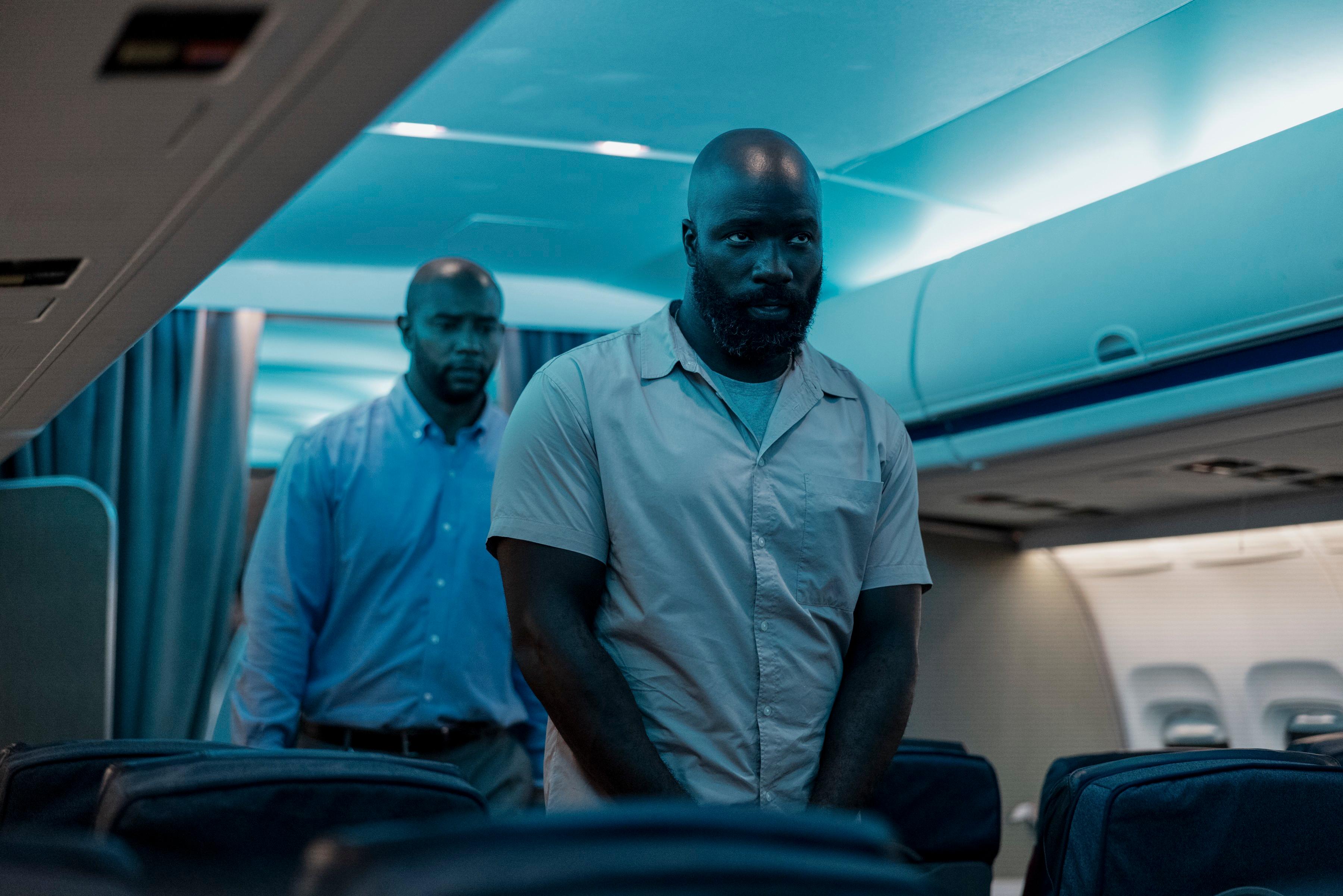 RCMP Officer Knight (Otis Winston, L) and Louis Gaspare (Mike Colter) boarding the plane, in "Plane." (Kenneth Rexach/Lionsgate)