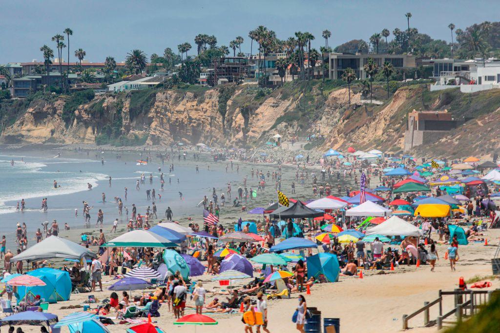 Beachgoers are seen along the shore in the Pacific Beach area of San Diego on July 4, 2020. (Sandy Huffaker/AFP via Getty Images)