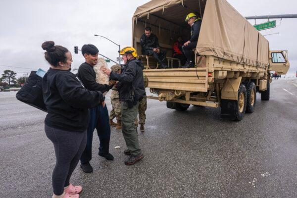 Two people and their dog are rescued from floodwaters in Watsonville, Calif., on March 11, 2023. (Nic Coury/AP Photo)