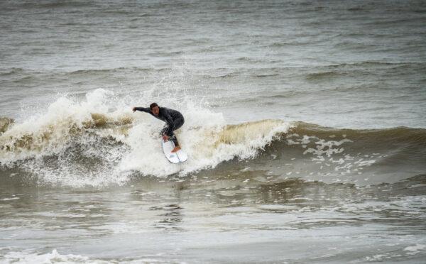 A surfers rides waves in San Clemente, Calif., on March 16, 2023. (John Fredricks/The Epoch Times)