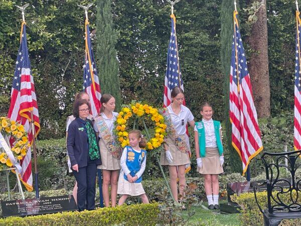 A local Girl Scout troop lays garlands on President and First Lady Nixon’s graves at the Nixon Library in Yorba Linda, Calif., on March 16, 2023. (Carol Cassis/The Epoch Times)