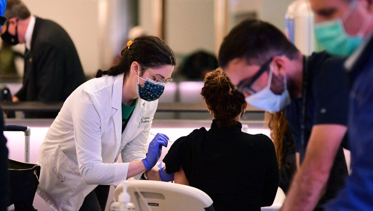A person receives a COVID-19 vaccine at Los Angeles International Airport on Dec. 22, 2021. (Frederic J. Brown/AFP via Getty Images)