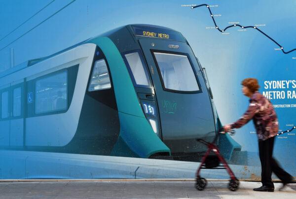 A woman walks in front of Sydney Metro billboard in Sydney, Australia on May 1, 2018. (Saeed Khan/AFP via Getty Images)