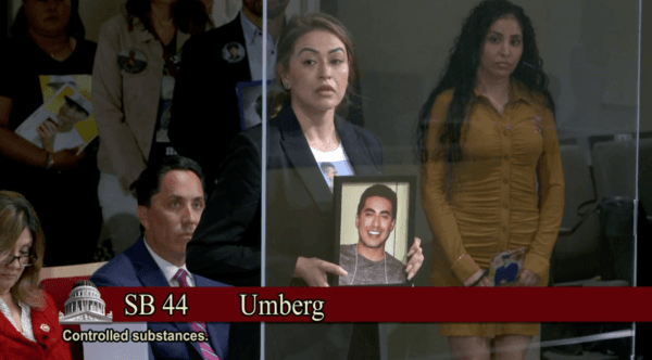 A mother holding a photo of her son, a fentanyl poisoning victim, voices support for fentanyl legislation at a Senate Public Safety Committee hearing in Sacramento on April 25, 2023. (Screenshot via California State Senate)