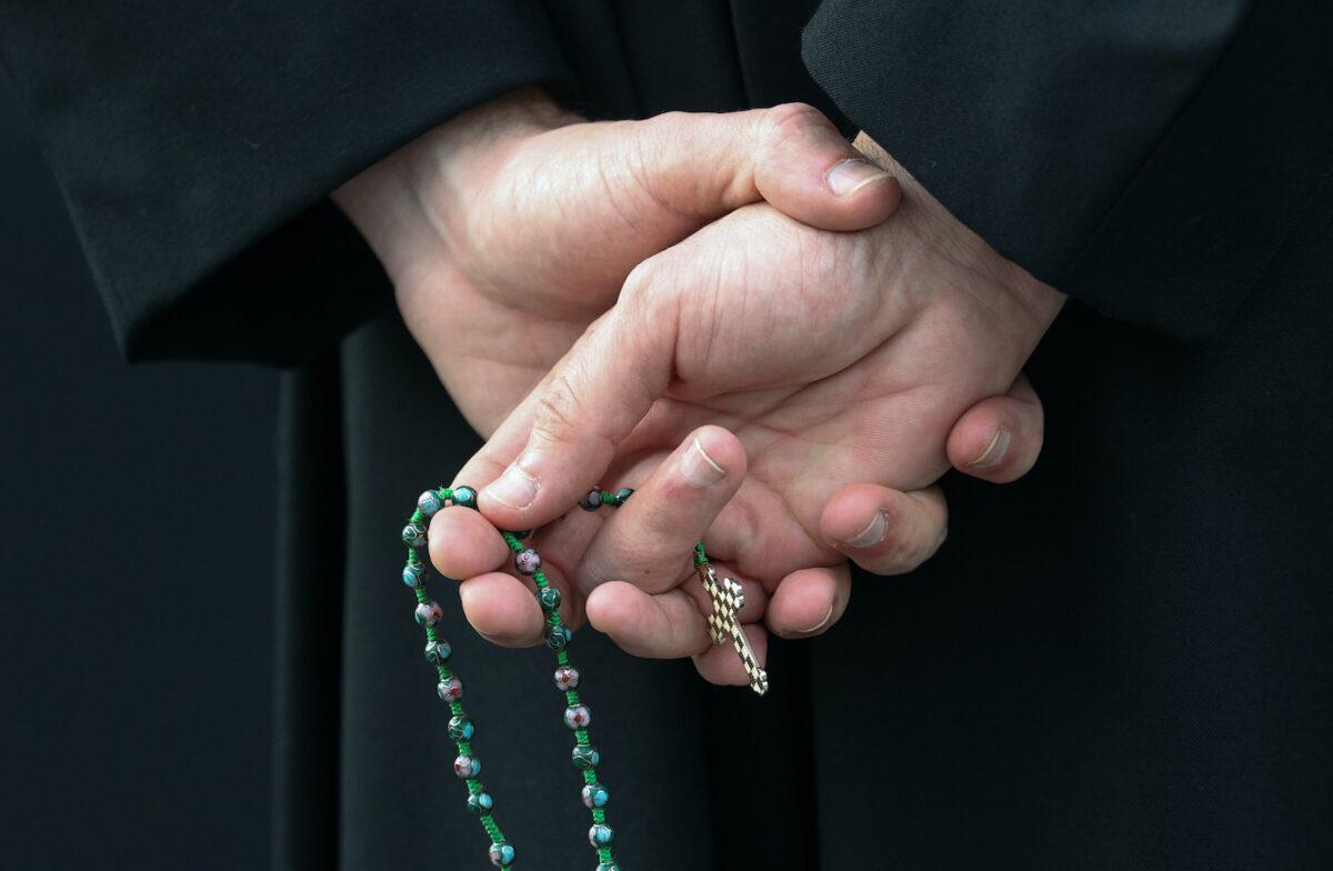A man holds rosary beads outside a U.S. Catholic church. (Rob Carr/Getty Images)
