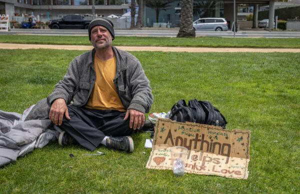 Bryan Paarlberg, who receives free meth pipes from the Venice Family Clinic, sits near his collection of items in Santa Monica, Calif., on June 2, 2023. (John Fredricks/The Epoch Times)