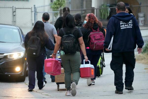 Los Angeles County Public Health Emergency Operations officials leave St. Anthony's Croatian Catholic Church after evaluating newly arrived migrants being housed in the Chinatown area of Los Angeles on June 14, 2023. (AP Photo/Damian Dovarganes)