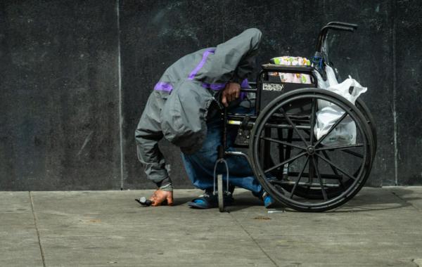 A homeless man sits passed out next to an empty syringe in San Francisco on Feb. 23, 2023. (John Fredricks/The Epoch Times)
