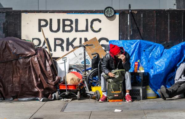 A man camps out in a street in San Francisco on Feb. 23, 2023. (John Fredricks/The Epoch Times)
