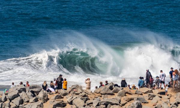 Beachgoers watch body surfers, surfers, and body boarders attempt to ride an 8–12-foot day at The Wedge in Newport Beach, Calif., on July 19, 2022. (John Fredricks/The Epoch Times)