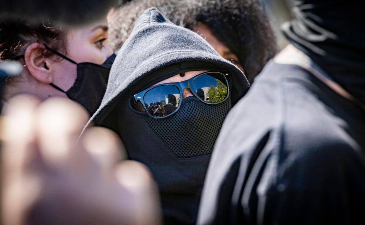 Men and women dressed in black attend a protest in Los Angeles, Calif., on Oct. 20, 2021. (John Fredricks/The Epoch Times)