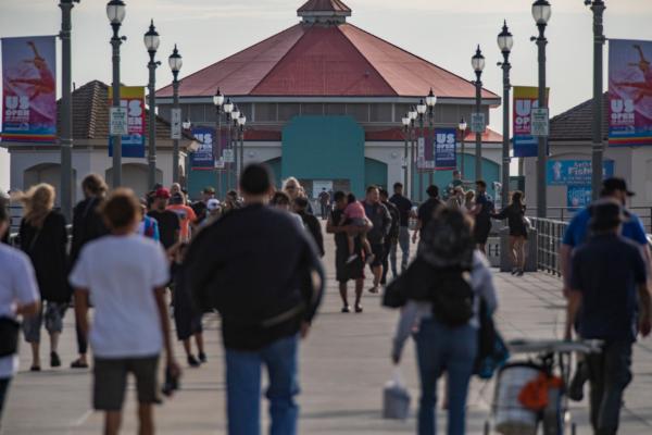 People gather to watch surfers practice for the US Open of Surfing in Huntington Beach, Calif., on Sept. 22, 2022. (John Fredricks/The Epoch Times)