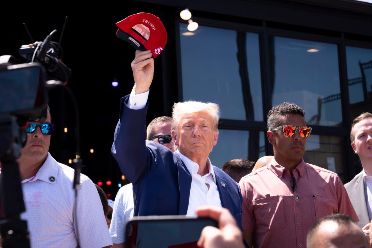 Former President Donald Trump tosses caps to the crowd at the Iowa State Fair in Des Moines, Iowa, on Aug. 12, 2023. (Madalina Vasiliu/The Epoch Times)