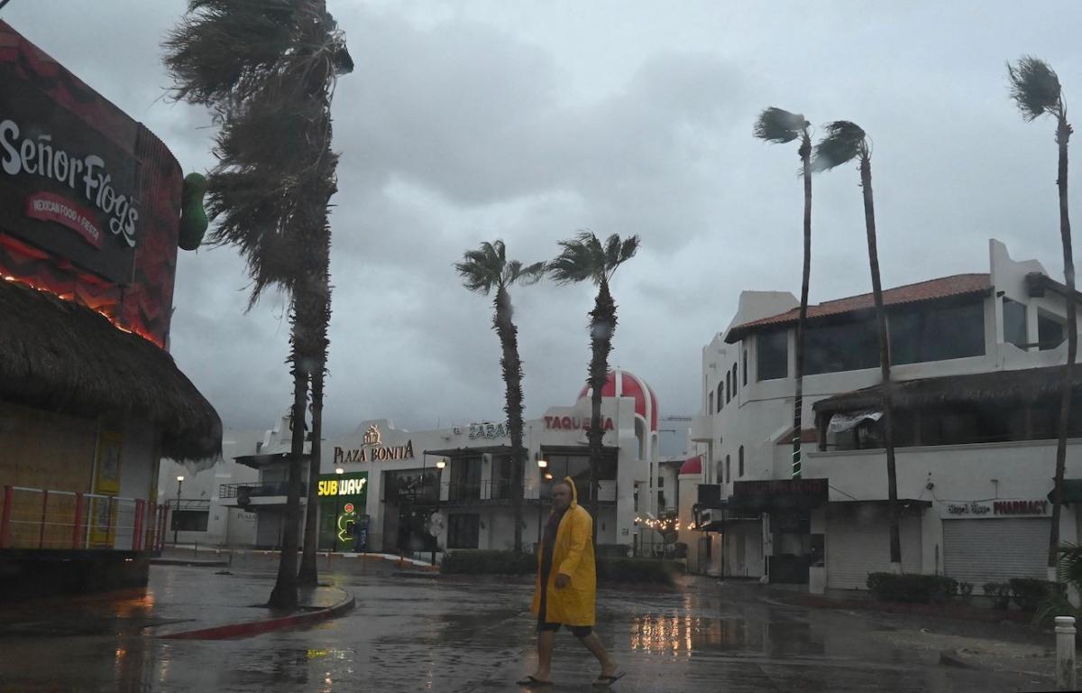 A man walks along a street in Cabo San Lucas, Baja California State, Mexico, as rain and gusts of wind of Hurricane Hilary reach the area, on Aug. 19, 2023. (Alfredo Estrella/AFP via Getty Images)