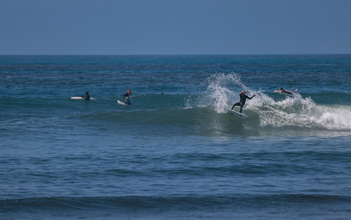 Surfers ride waves in front of the staging area of the Rip Curl WSL Finals of Lower Trestles in San Clemente, Calif., on Sept. 8, 2023. (John Fredricks/The Epoch Times)