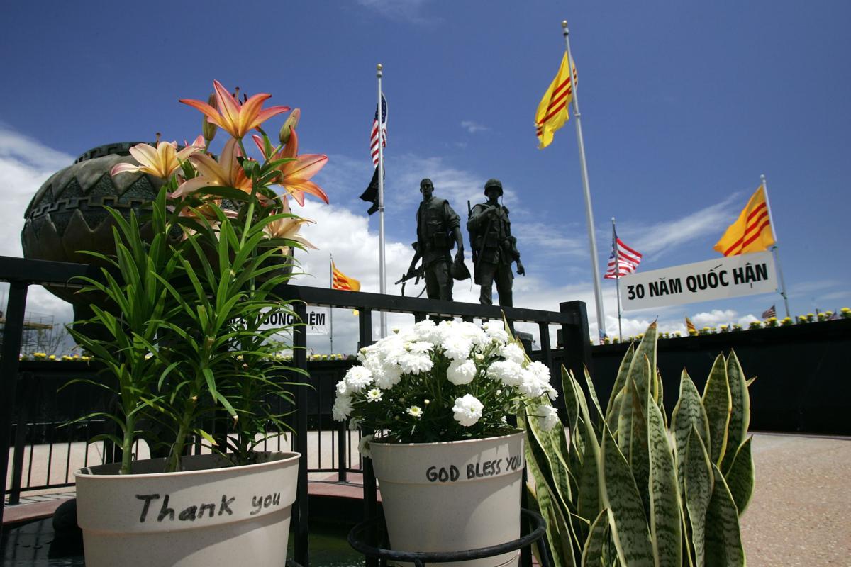 Flowers with messages of gratitude are left at the Vietnam War Memorial where a statue depicting an American soldier and a South Vietnamese soldier are surrounded by American and old-style Vietnamese flags near the Little Saigon section in Westminster, Calif., on April 28, 2005. (David McNew/Getty Images)