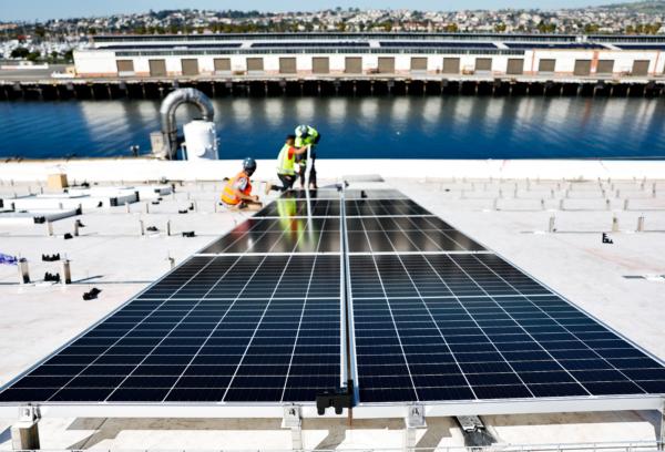 Workers install solar panels atop AltaSea's research and development facility at the Port of Los Angeles on April 21, 2023. (Mario Tama/Getty Images)