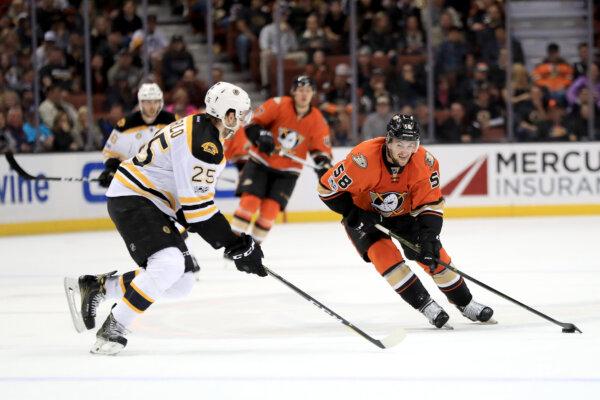 Nicolas Kerdiles (58) of the Anaheim Ducks moves around Brandon Carlo (25) of the Boston Bruins during the third period of a game at Honda Center in Anaheim, Calif., on Feb. 22, 2017. (Sean M. Haffey/Getty Images)