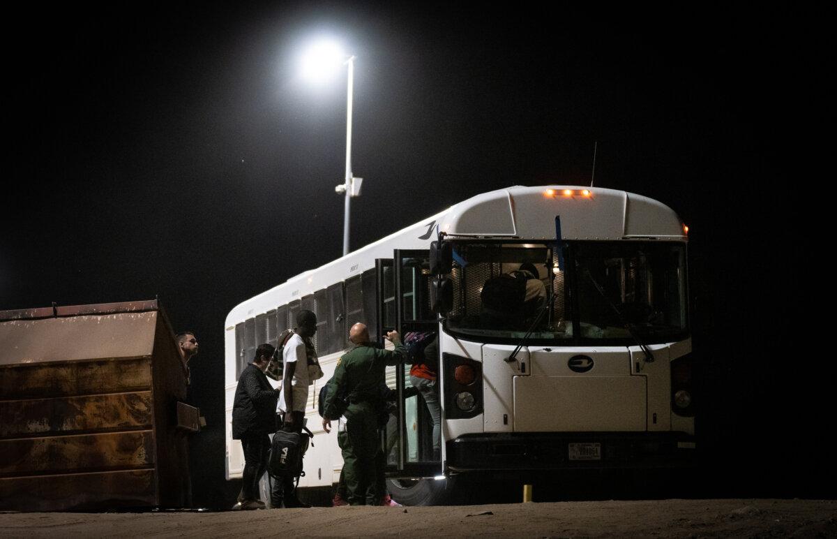 Unvetted illegal immigrants prepare to be transported by bus to processing facilities in Yuma, Ariz., on May 18, 2023. (John Fredricks/The Epoch Times)