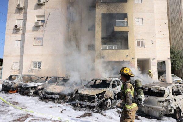 Israeli fire brigade teams douse the blaze in a partking lot outside a residential building following a rocket attack from the Gaza Strip in the southern Israeli city of Ashkelon, on October 7, 2023. (Ahmad Gharabli/AFP via Getty Images)