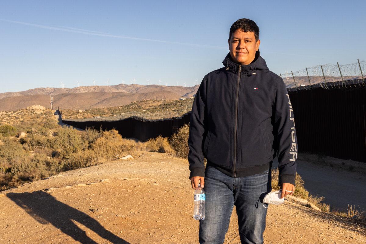 Gerson, a recently arrived Columbian migrant stands near the border wall in Jacumba, Calif., on Oct. 31, 2023. (John Fredricks/The Epoch Times)
