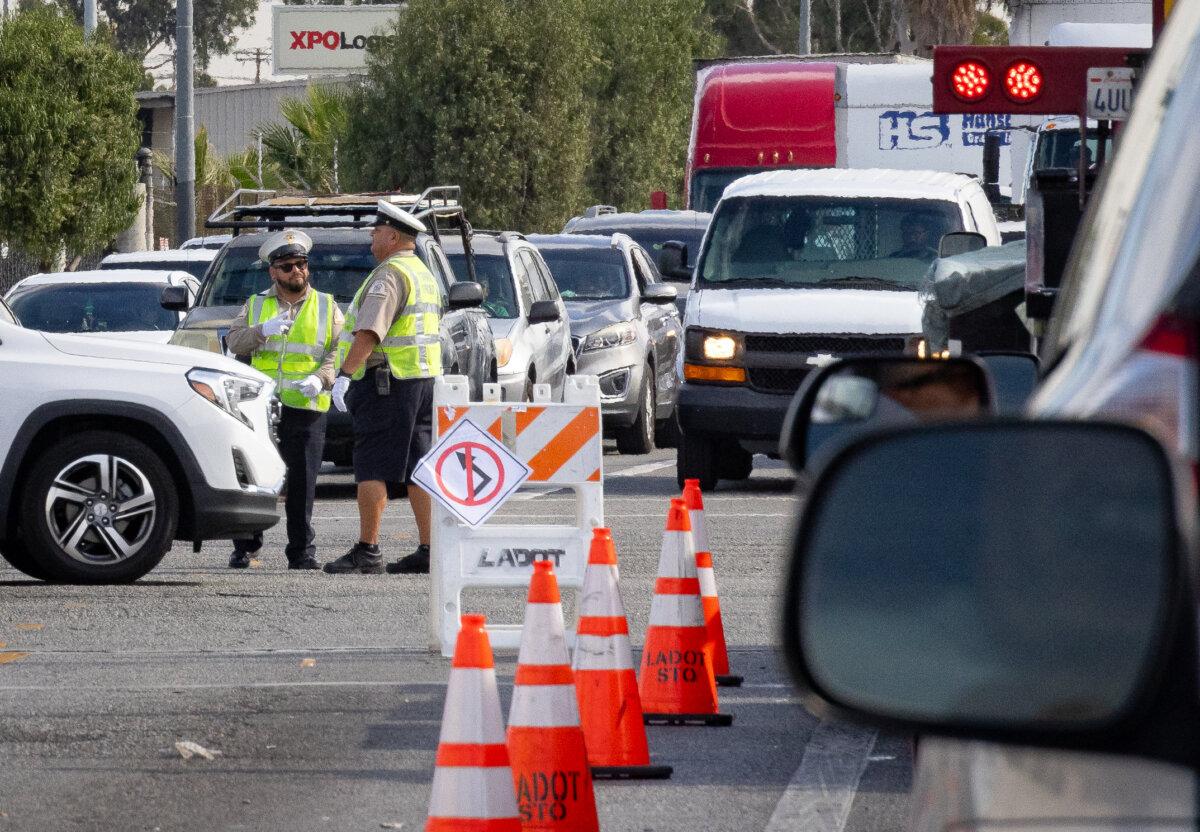 Traffic officers help to divert traffic after a temporary closure of the 10 freeway in Los Angeles on Nov. 13, 2023. (John Fredricks/The Epoch Times)