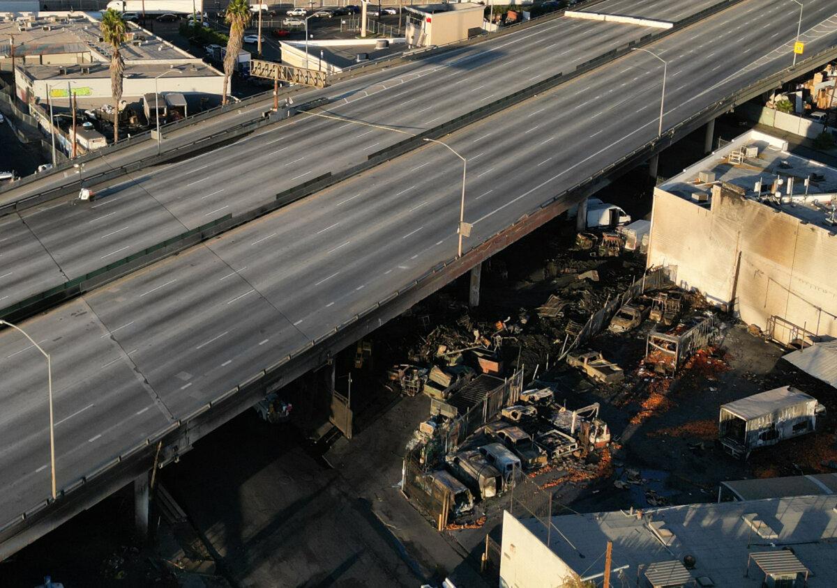 An aerial picture shows burnt cars and other debris under the I-10 freeway after a large fire led to the shutdown of the freeway, also called the Santa Monica Freeway, in both directions, in Los Angeles on Nov. 13, 2023. (Robyn Beck/AFP via Getty Images)