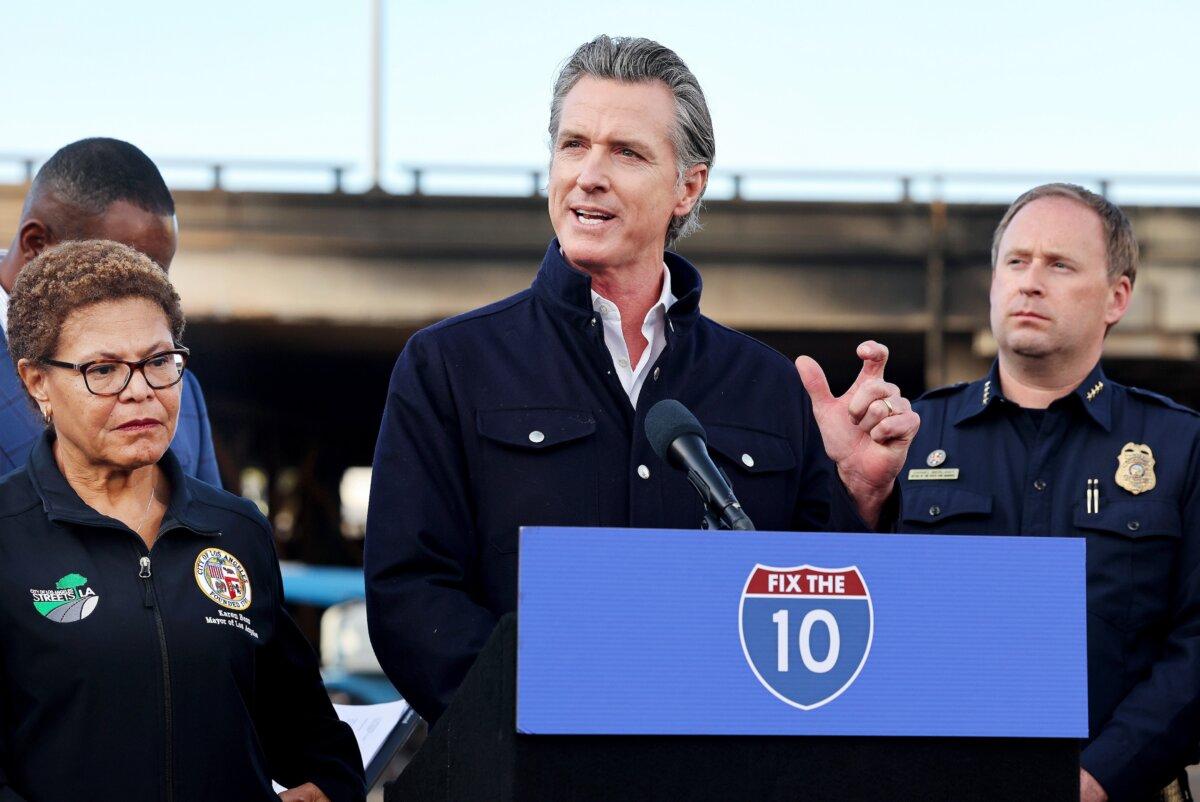 California Gov. Gavin Newsom (C) speaks as Los Angeles Mayor Karen Bass (L) listens at a press conference near the closed I-10 elevated freeway following a large pallet fire, which occurred Nov. 11 at a storage yard beneath the freeway, in Los Angeles on Nov. 13, 2023. (Mario Tama/Getty Images)