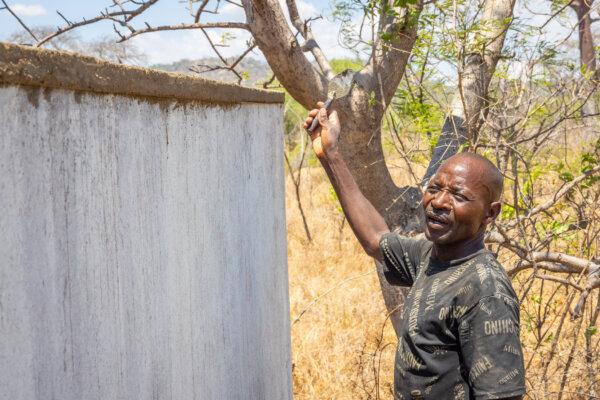 A man smooths concrete at a Blossom Project site in the Mongochi District, Malawi, on Nov. 6, 2023. (John Fredricks/The Epoch Times)