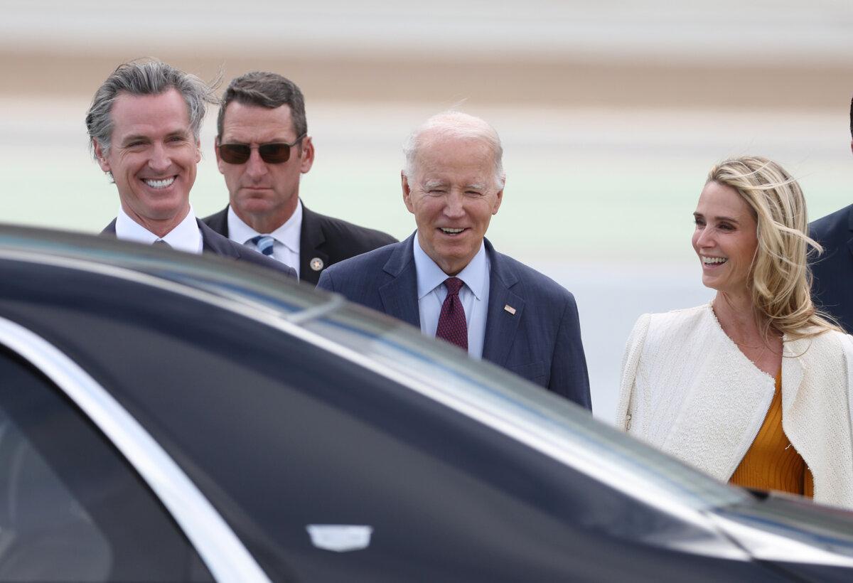President Joe Biden (C) talks with California Gov. Gavin Newsom (L) and his wife Jennifer Siebel Newsom (R) after arriving at San Francisco International Airport ahead of the APEC summit in San Francisco, California, on Nov. 14, 2023. (Justin Sullivan/Getty Images)