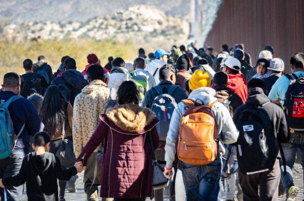 Illegal immigrants who passed through a gap in the U.S. border wall await processing by Border Patrol agents in Jacumba, Calif., on Dec. 7, 2023. (John Fredricks/The Epoch Times)