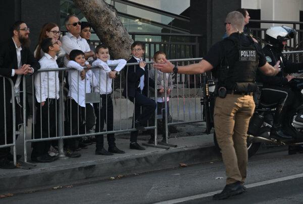 Kids speak with a Secret Service agent as they wait to watch the motorcade with President Joe Biden leave his hotel in Beverly Hills, Calif., on Dec. 9, 2023. (Andrew Caballero-Reynolds/AFP via Getty Images)
