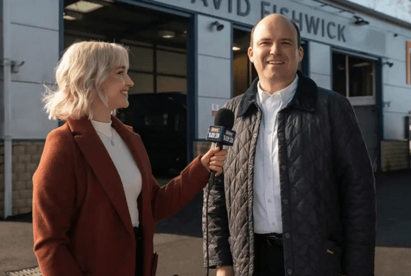Henrietta, a journalist (Naomi Battrick) interviewing Dave (Rory Kinnear), in "Bank of Dave." (Ingenious Media/Netflix)