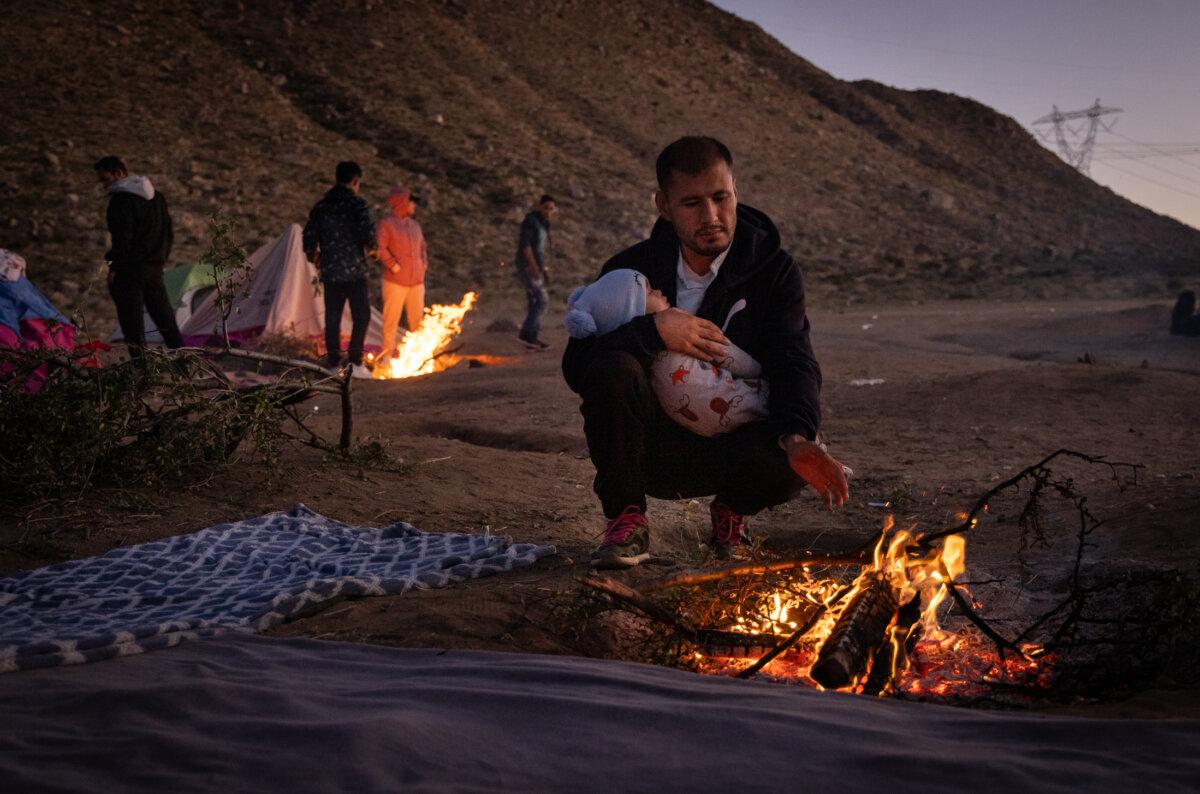 Illegal immigrants from Afghanistan who passed through a gap in the U.S. border wall await processing by Border Patrol agents in Jacumba, Calif., on Dec. 6, 2023. (John Fredricks/The Epoch Times)