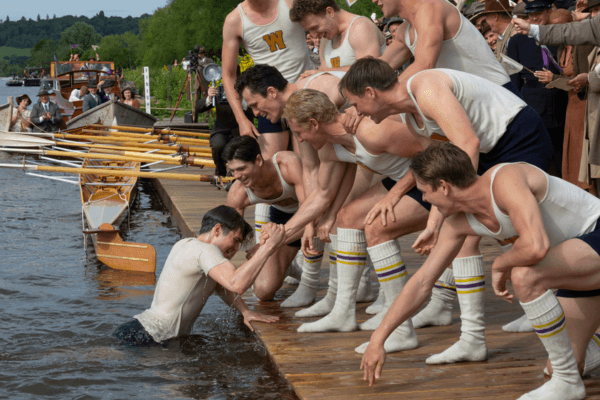 Coxswain Bobby Moch (Luke Slattery) being pulled out of the river by Joe Rantz (Callum Turner) after the traditional post-win coxswain-toss celebration, in “The Boys in the Boat.” (Laurie Sparham/Metro-Goldwyn-Mayer Pictures)
