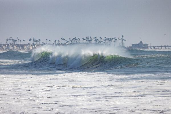 Beachgoers and surfers enjoy high surf conditions in Newport Beach, Calif., on Dec. 28, 2023. (John Fredricks/The Epoch Times)