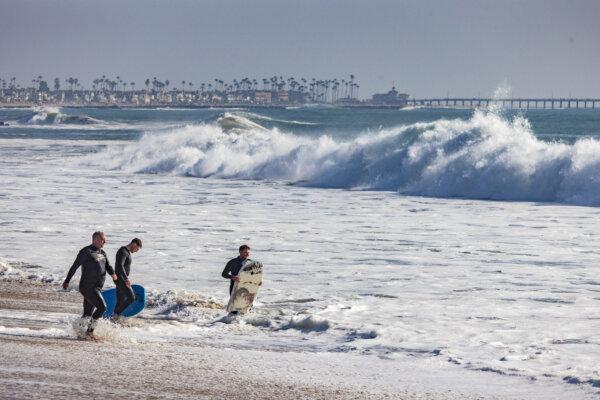 Beachgoers and surfers enjoy high surf conditions in Newport Beach, Calif., on Dec. 28, 2023. (John Fredricks/The Epoch Times)