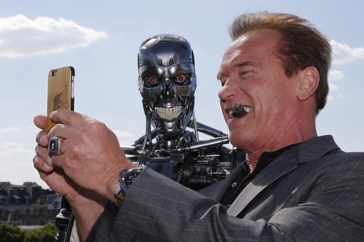 Actor and former governor of California Arnold Schwarzenegger takes a selfie photo with the Terminator animatronics robot during a photo call for the film "Terminator Genisys" in Paris on June 19, 2015. (Francois Guillot/AFP via Getty Images)
