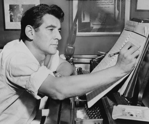 In 1955, Leonard Bernstein annotates the piano score of a musical work. (Public Domain)