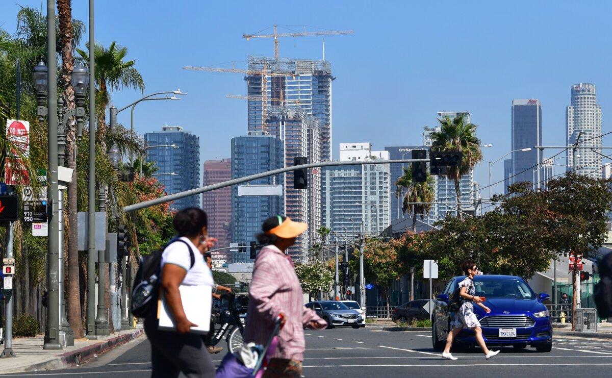 Pedestrians cross a street against a backdrop of luxury high-rise apartments under construction in Los Angeles on Oct. 8, 2019. (Frederic J. Brown/AFP via Getty Images)