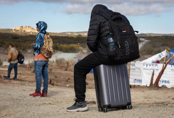 Illegal immigrants gather after crossing the United States border wall in Jacumba, Calif., on Jan. 10, 2024. (John Fredricks/The Epoch Times)