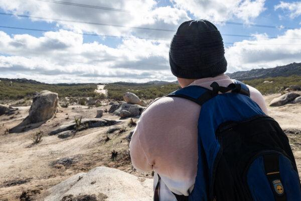A Peruvian illegal immigrant looks at the United States border wall in Jacumba, Calif., on Jan. 10, 2024. (John Fredricks/The Epoch Times)