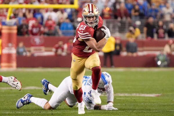 San Francisco 49ers running back Christian McCaffrey (23) runs in front of Detroit Lions defensive end Romeo Okwara during the second half of the NFC Championship NFL football game in Santa Clara, Calif., on Jan. 28, 2024. (Mark J. Terrill/AP Photo)