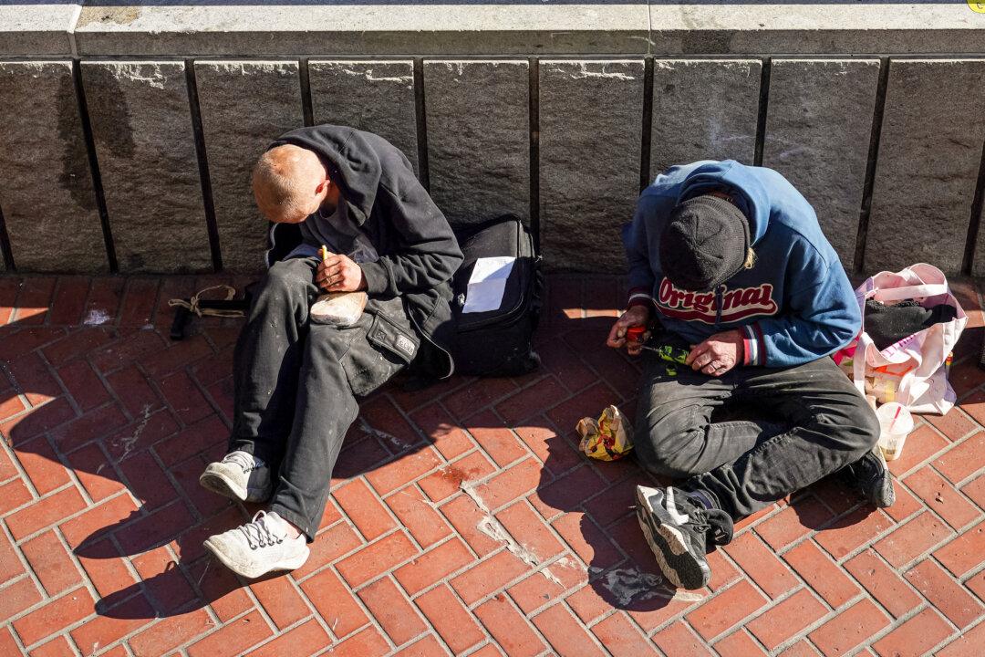 Homeless people sit at a public transit station near APEC Summit headquarters in downtown San Francisco on Nov. 11, 2023. The worsening situation puts greater strains on municipalities, experts say.