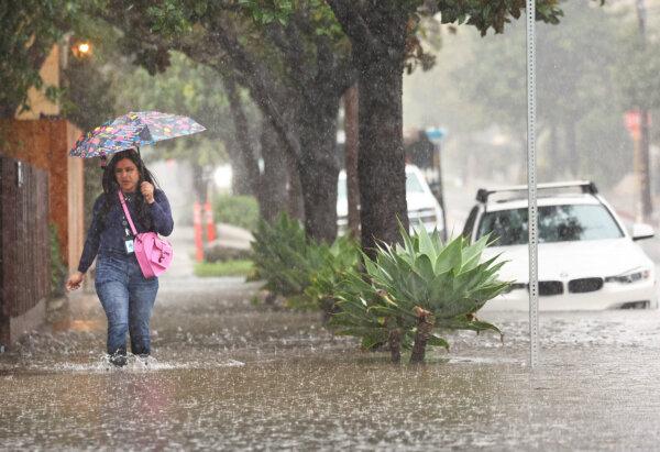 A person walks through flood waters as a powerful long-duration atmospheric river storm, the second in less than a week, affects Santa Barbara, Calif., on Feb. 4, 2024. (Mario Tama/Getty Images)