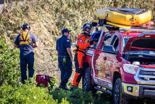First reponders work together in extracting two bodies found in the Tijuana River outside of San Diego, Calif., on Feb. 22, 2024. (John Fredricks/The Epoch Times)