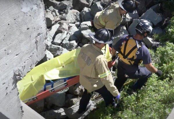 Firefighters from San Diego Fire Department carrying a body found in the Tijuana River in San Ysidro, Calif., on Feb. 22, 2024. (YouTube/Screenshot via California Insider)