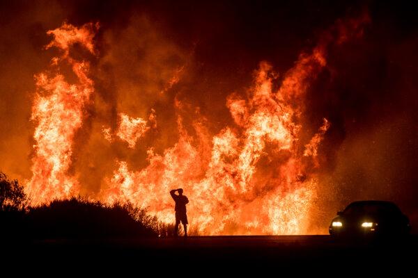 A motorist on Highway 101 watches flames from the Thomas fire north of Ventura on Dec. 6, 2017. (Noah Berger/AP Photo)