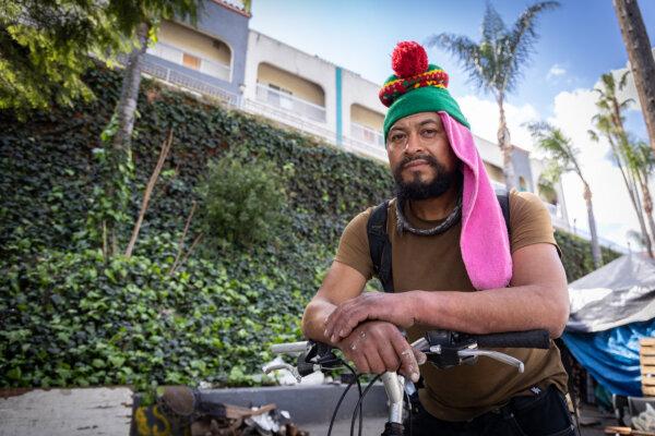 A homeless man stands in front of an Inside Safe site in Los Angeles on March 4, 2024. (John Fredricks/The Epoch Times)